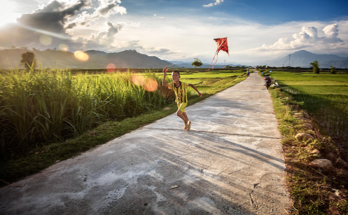 Enfant jouant avec un cerf-volant au Vietnam.