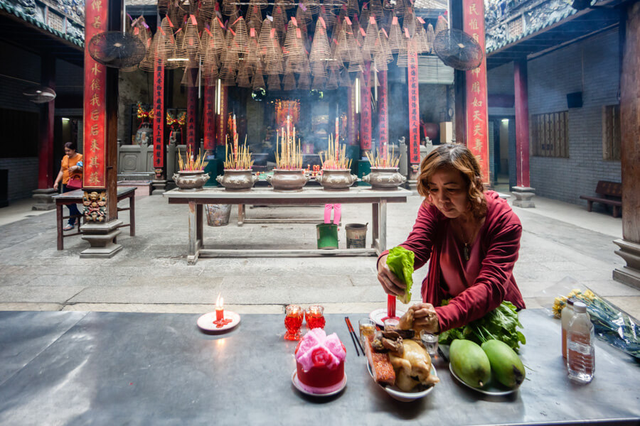 femme faisant des offrandes dans un temple.